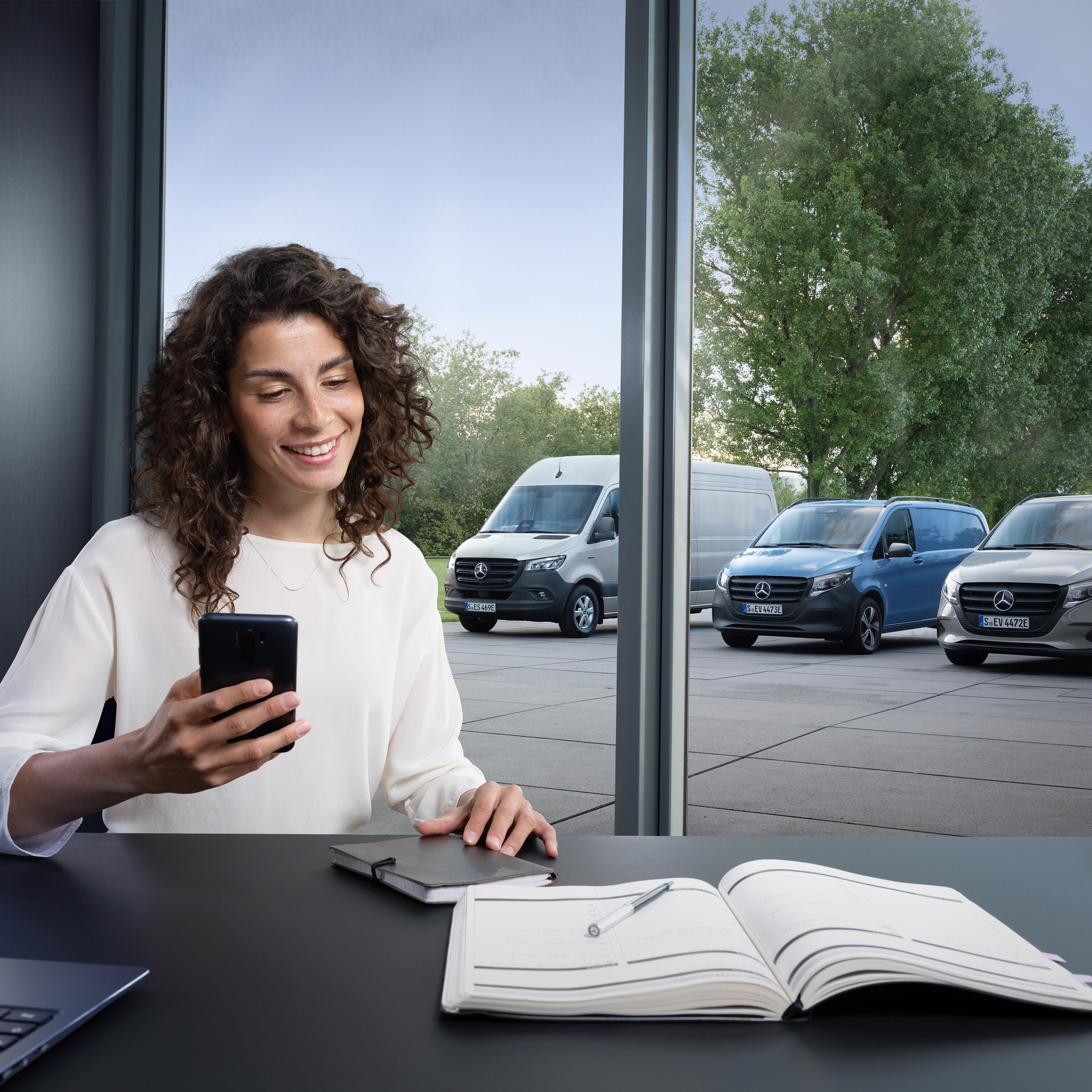 Una donna con uno smartphone e un planning sul tavolo