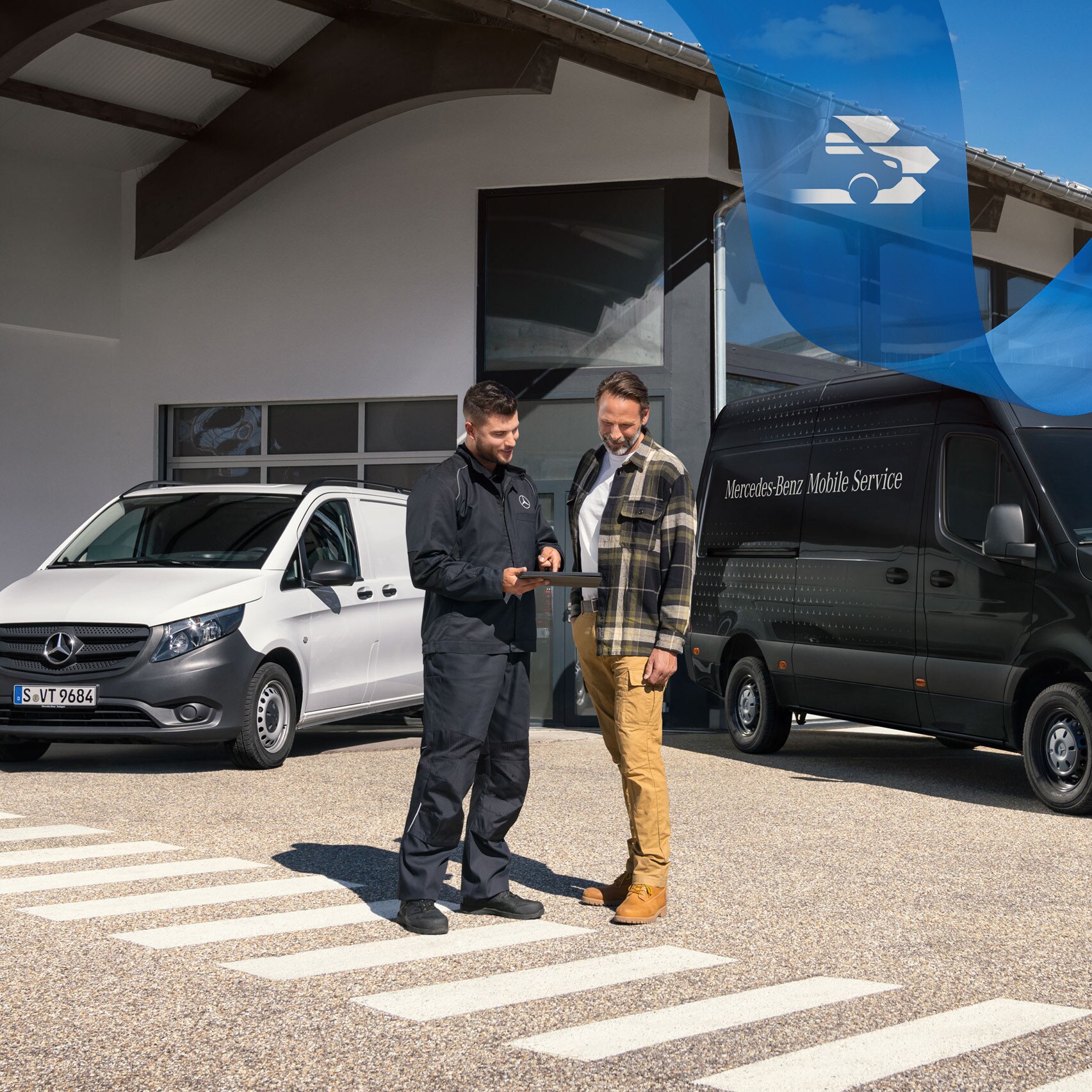 Due uomini parlano davanti a un veicolo commerciale Mercedes-Benz Vito bianco e a un veicolo commerciale Mercedes-Benz Sprinter nero.