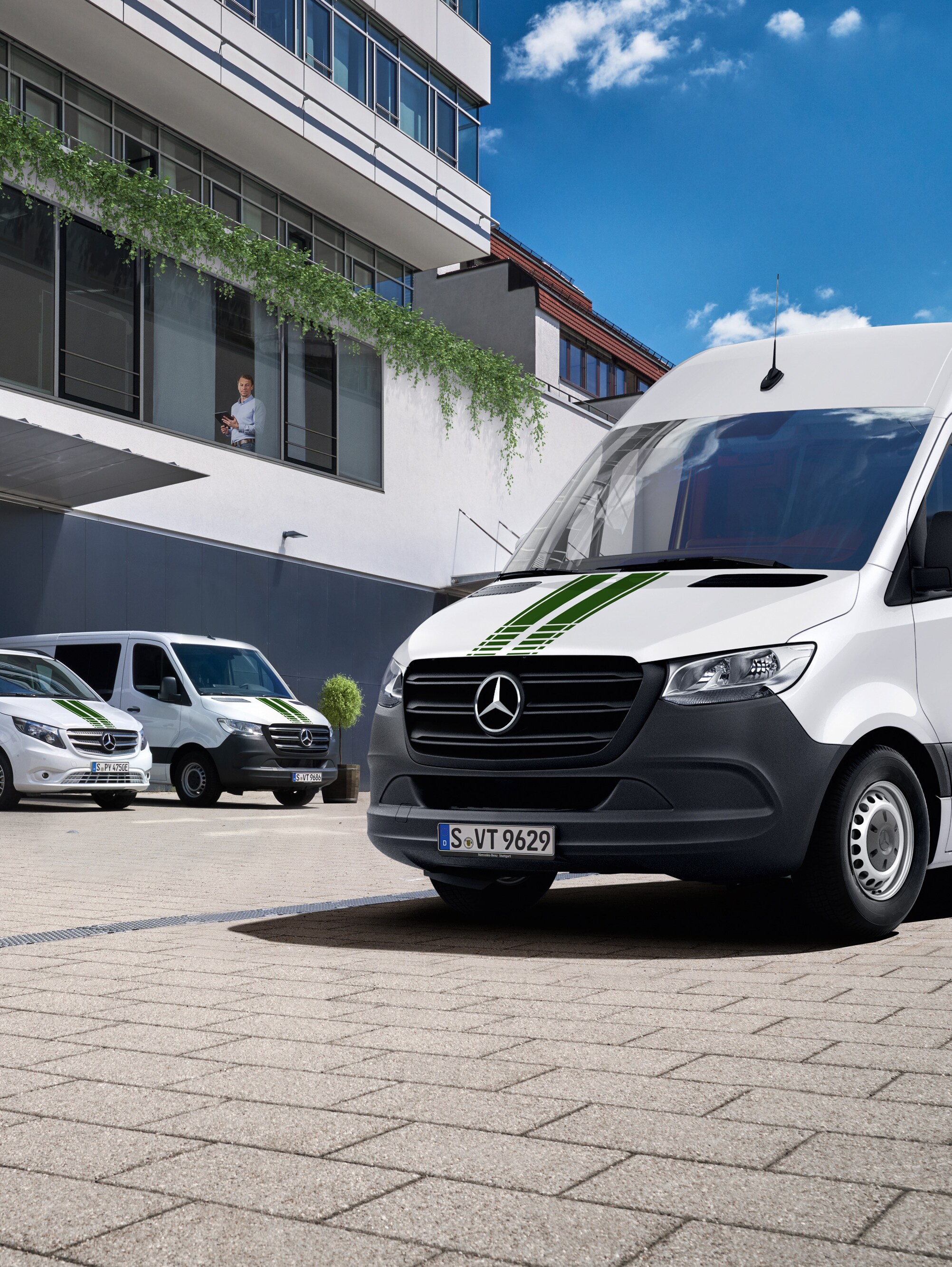 Una flotta di veicoli commerciali Mercedes-Benz davanti a un edificio