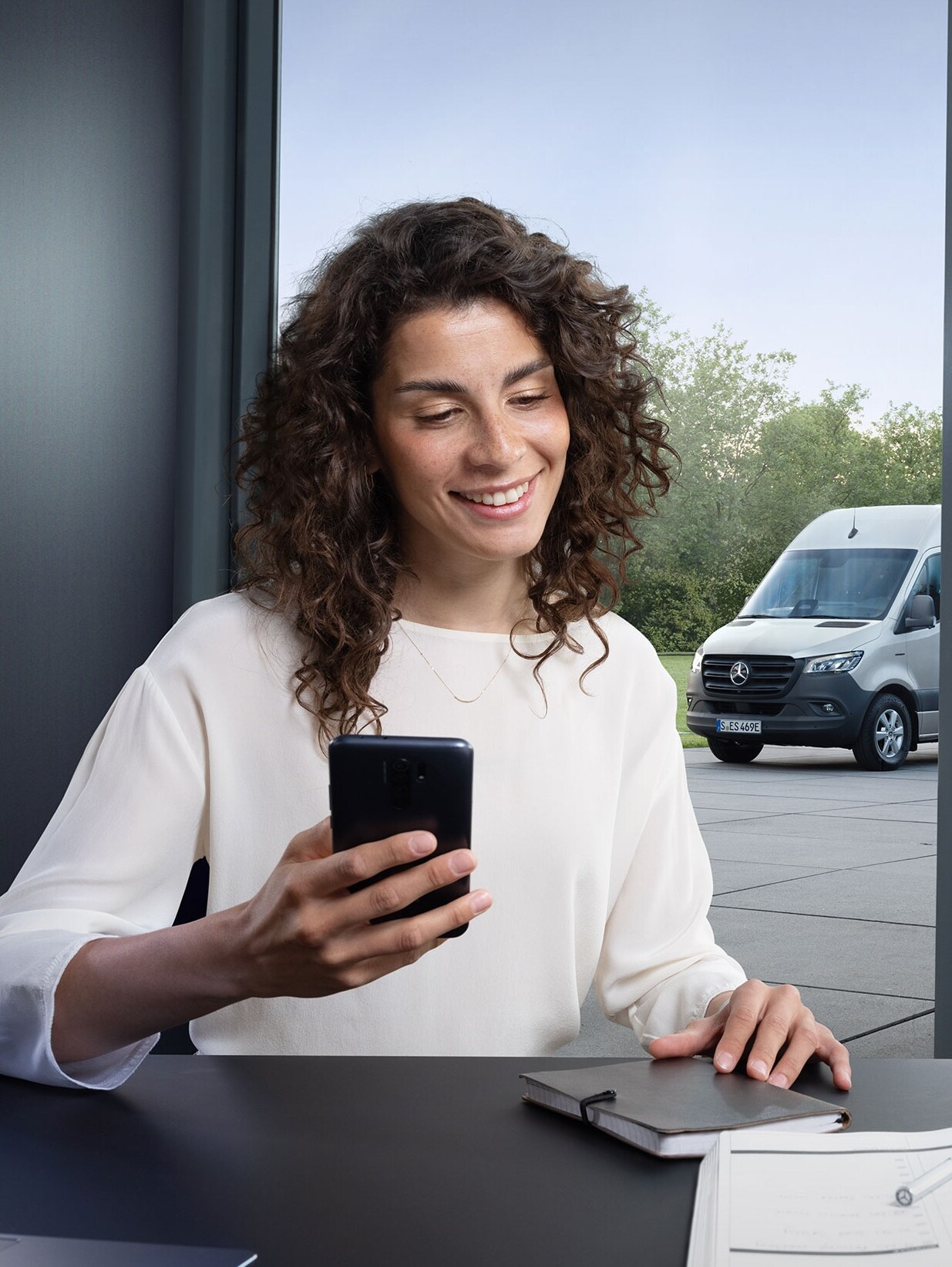Una donna utilizza uno smartphone per controllare il monitoraggio della flotta