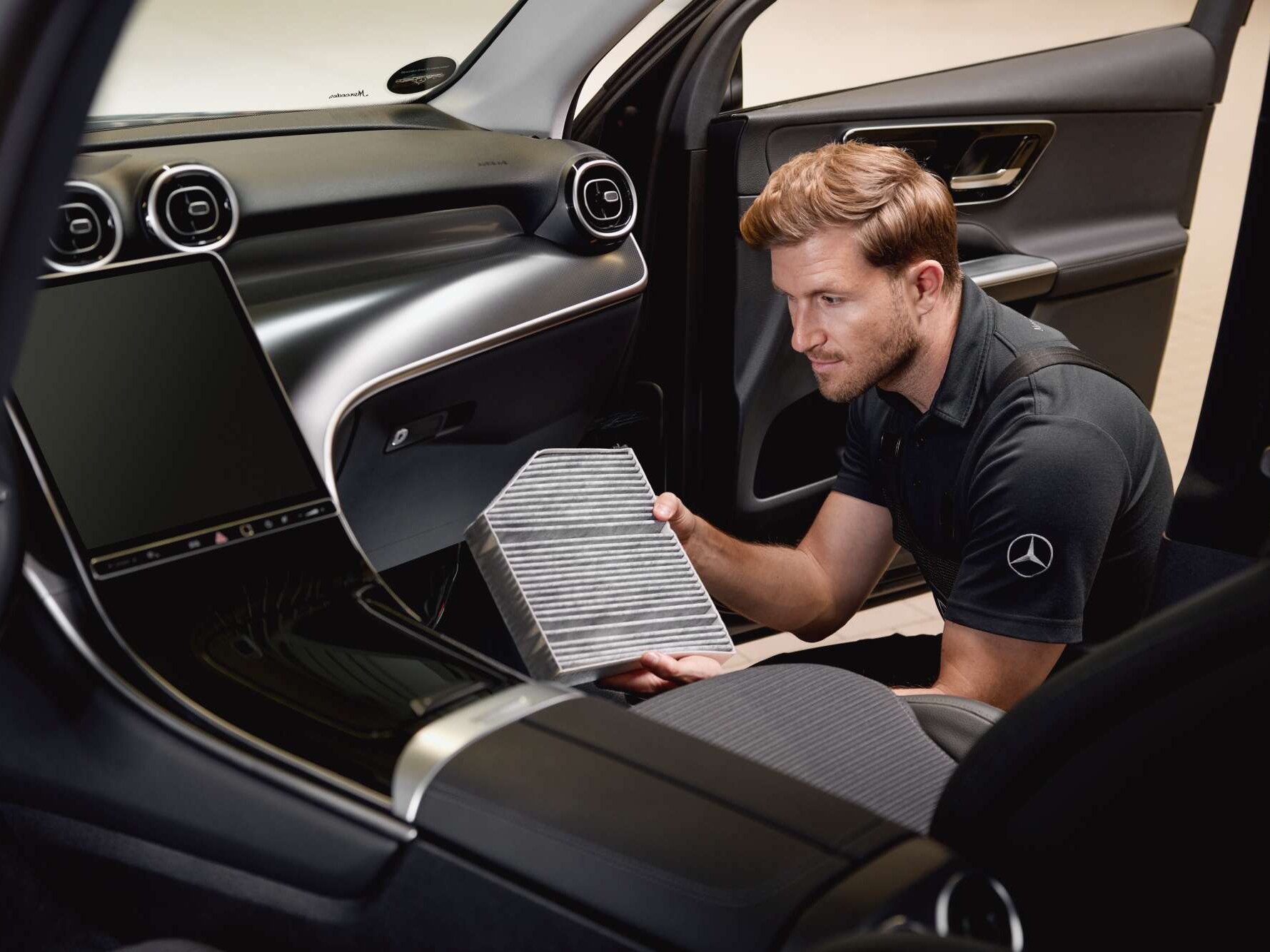 Un intervento di manutenzione degli interni: un filtro dell'aria dell'abitacolo viene sostituito utilizzando un ricambio originale Mercedes-Benz.