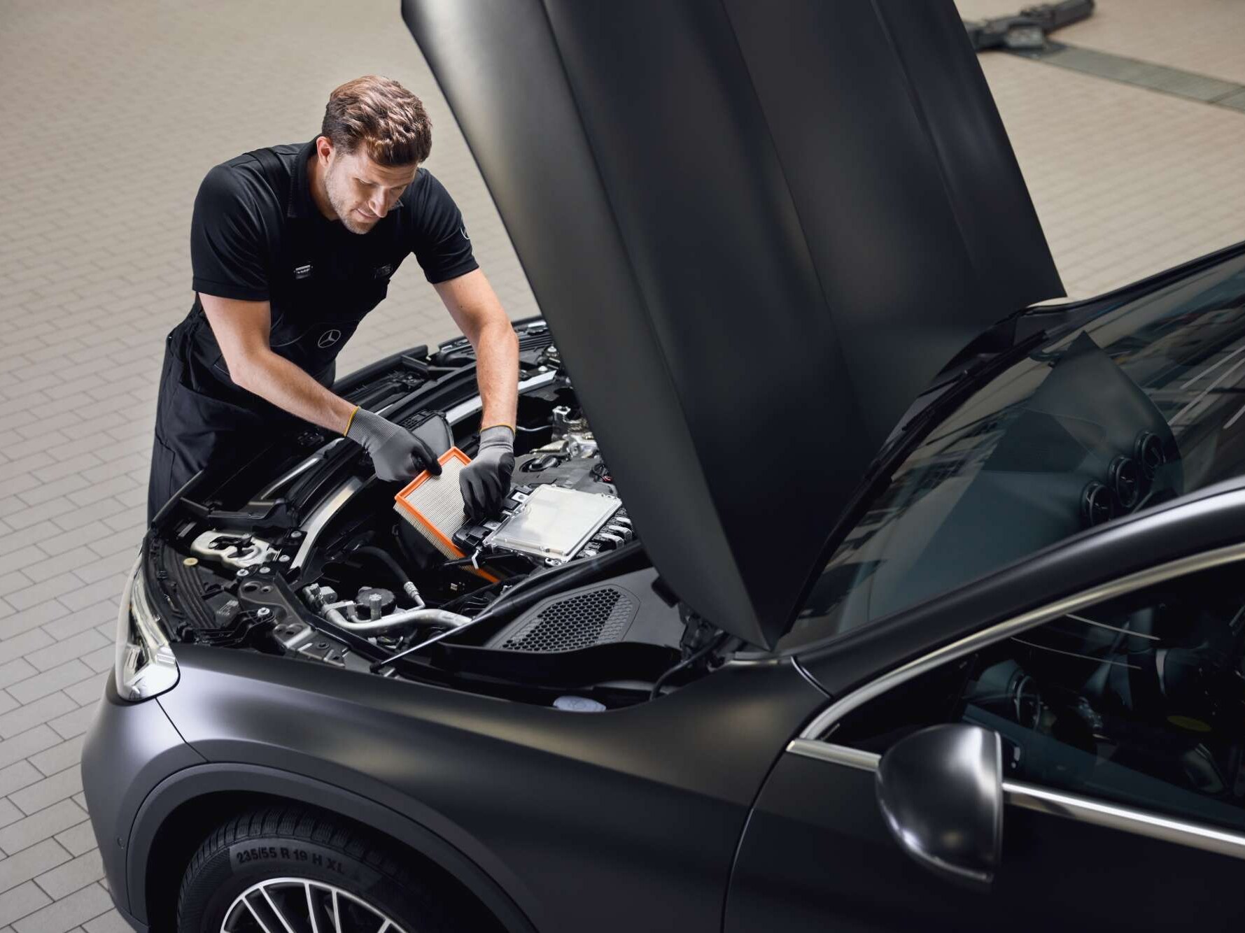 Un intervento di manutenzione sul motore: un filtro dell'aria per il motore viene sostituito utilizzando un ricambio originale Mercedes-Benz.