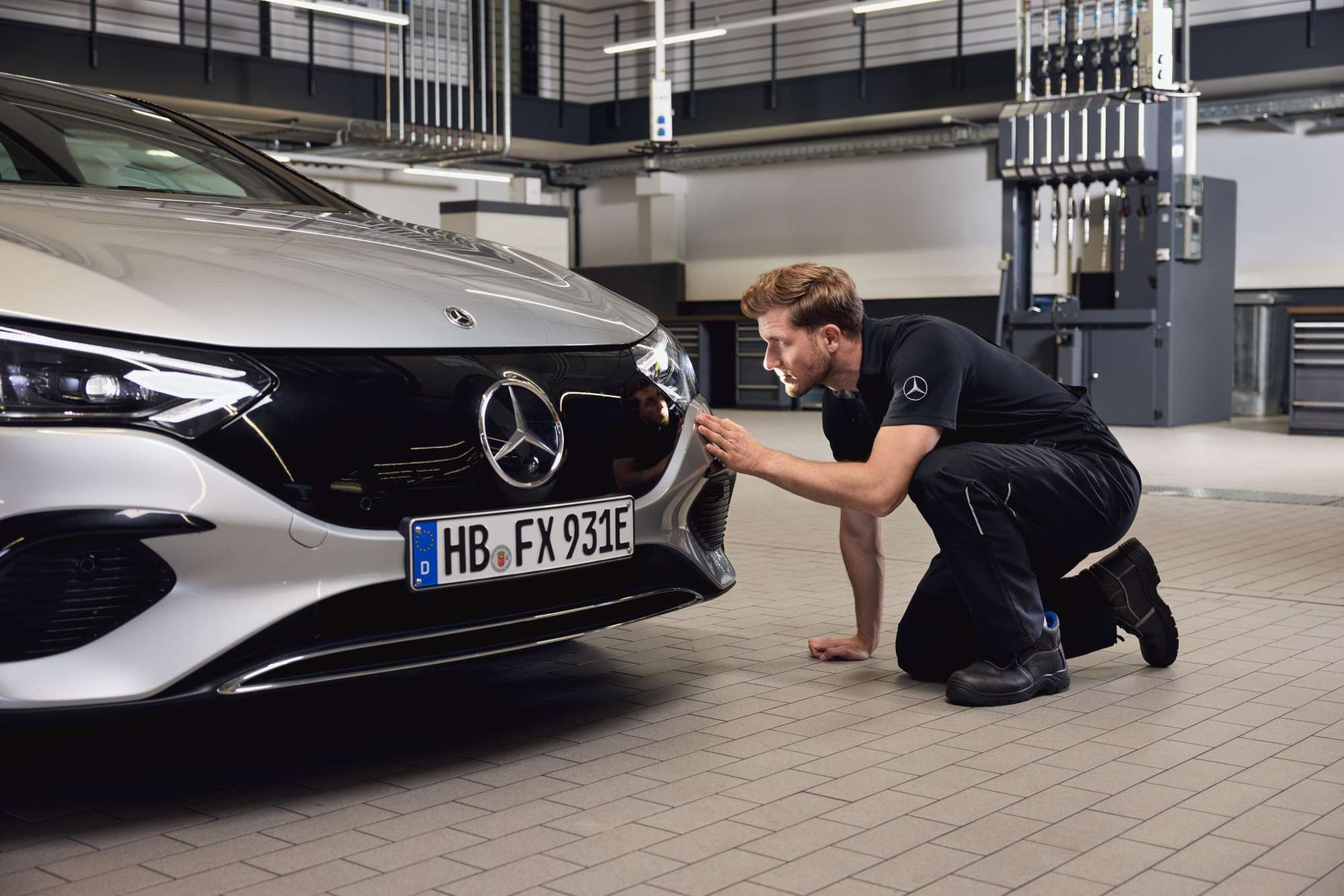 Ricambi Originali | Mercedes-Benz Meccanico seduto davanti a una vettura Mercedes-Benz
