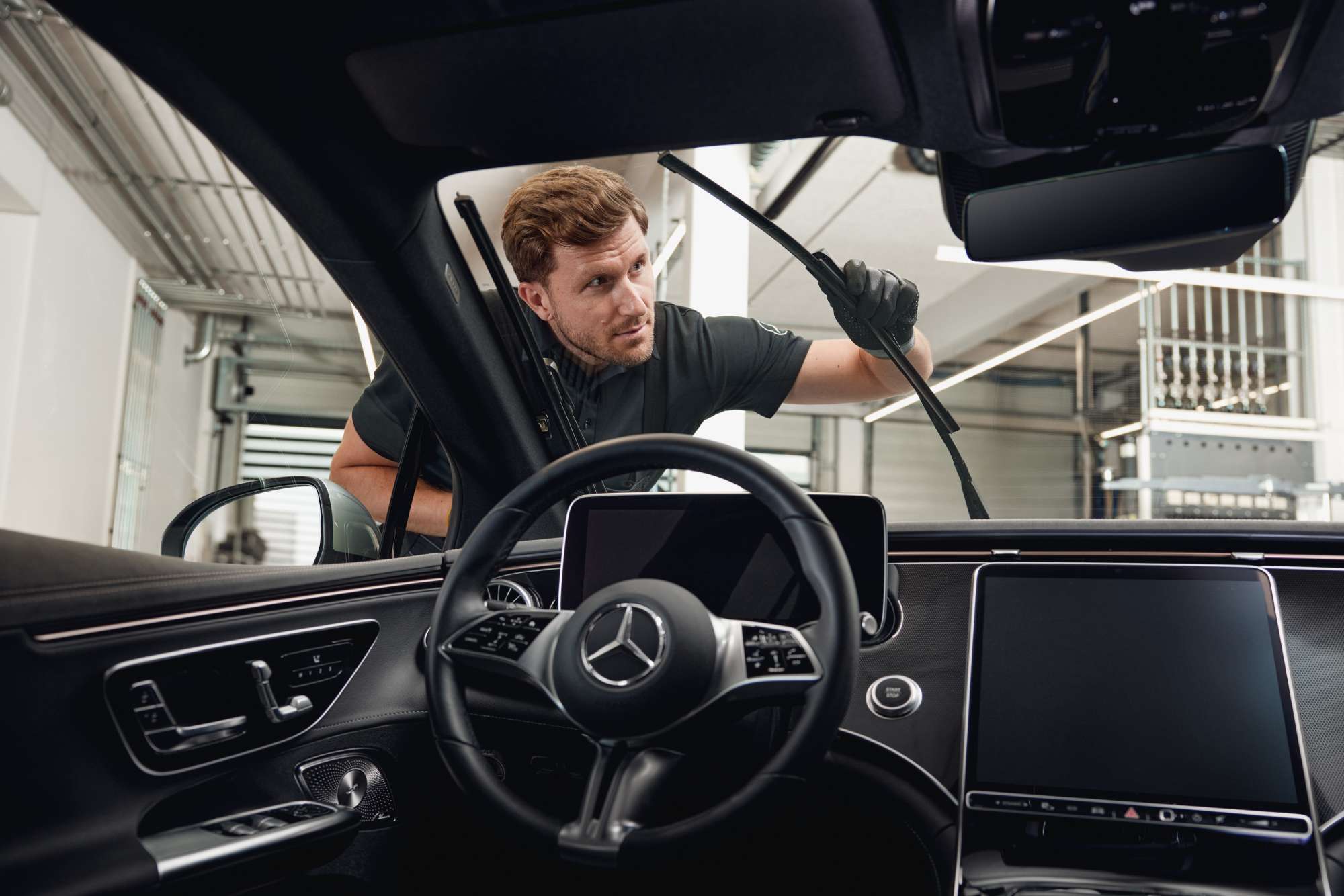 Spazzole tergicristallo originali Mercedes-Benz Vista interna di un veicolo Mercedes-Benz mentre un tecnico sostituisce le spazzole del tergicristallo.