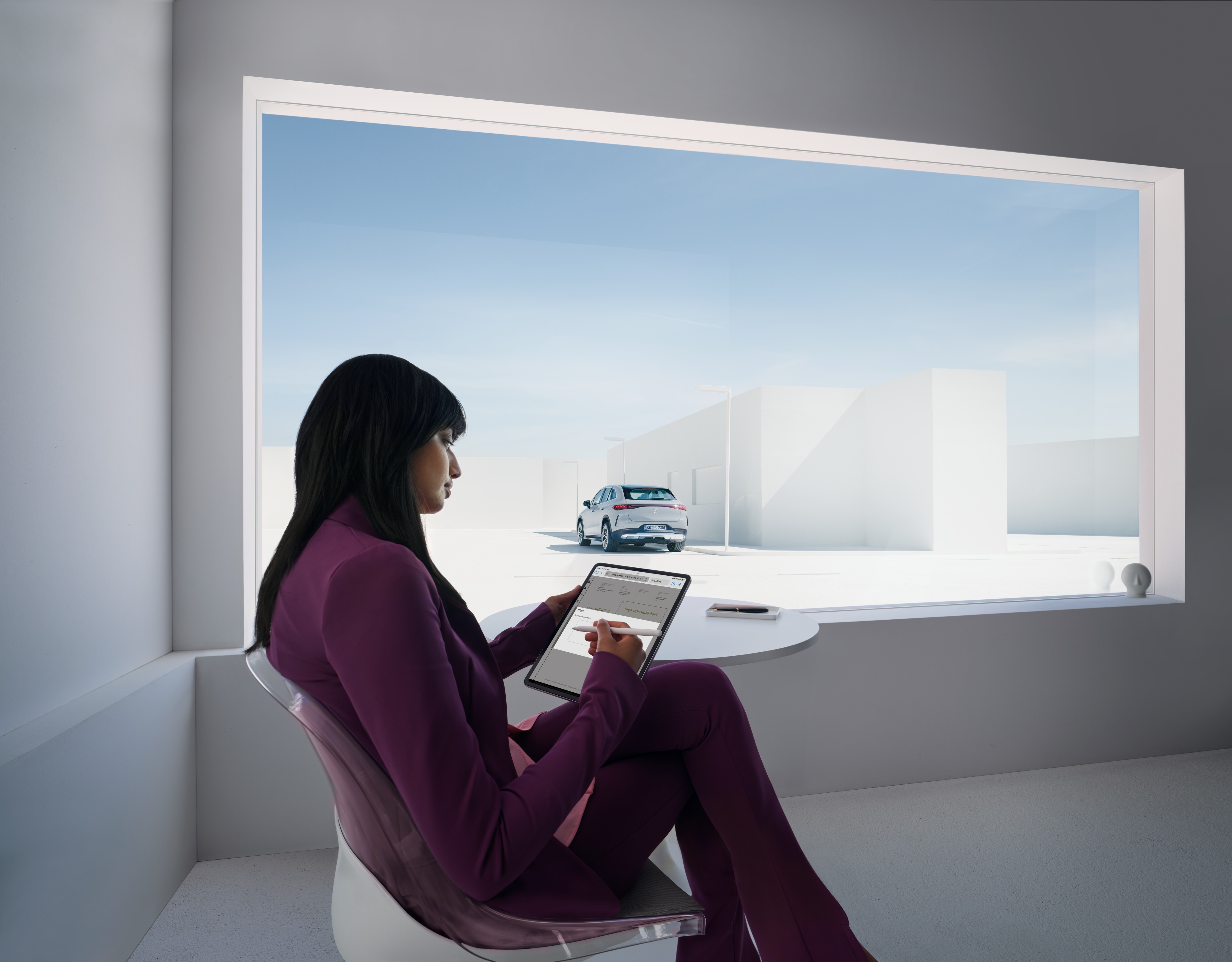 Privacy | Mercedes-Benz Donna con un tablet in mano con un'auto Mercedes-Benz sullo sfondo