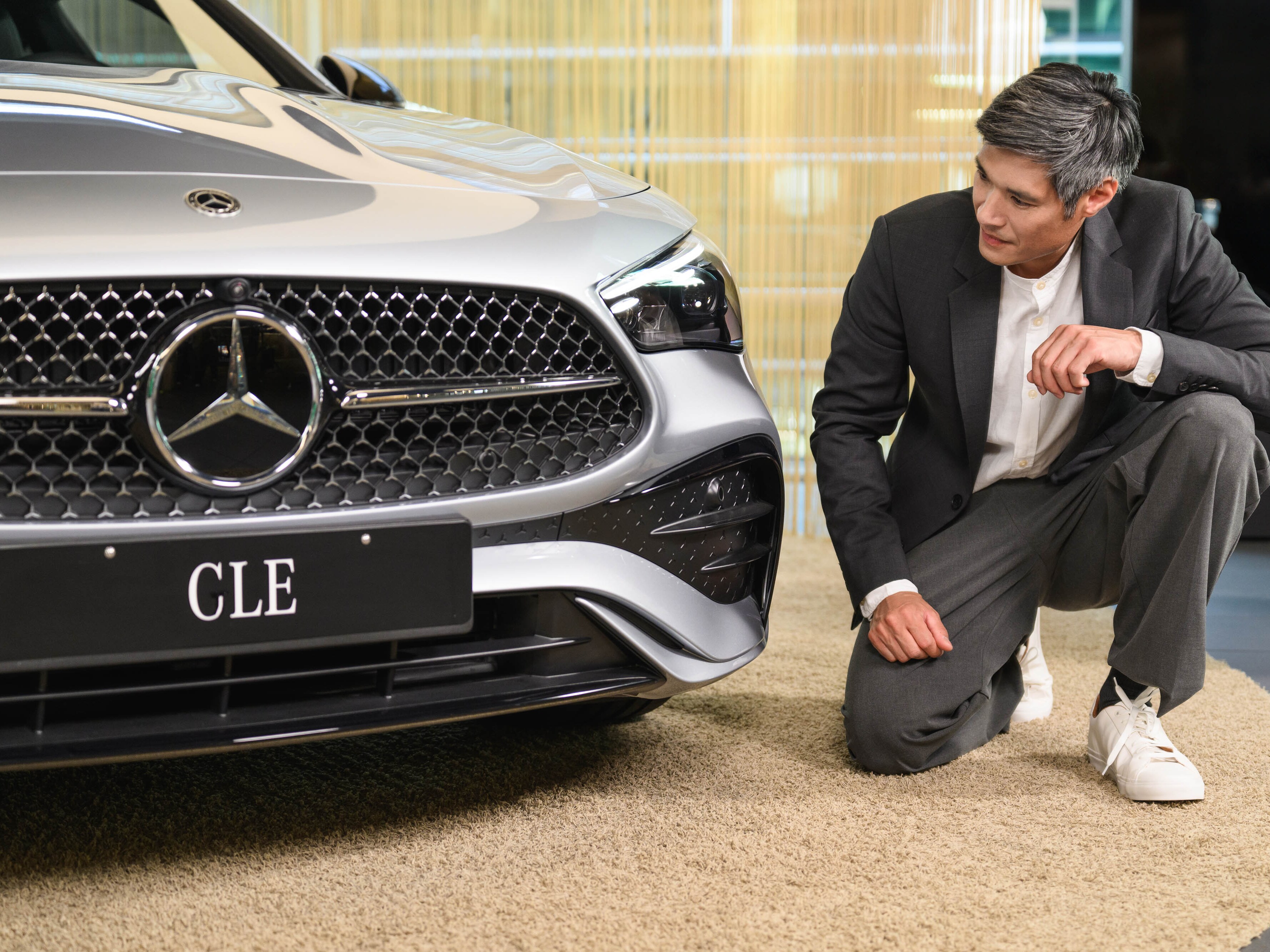 Una persona che guarda il cofano di una Mercedes-Benz