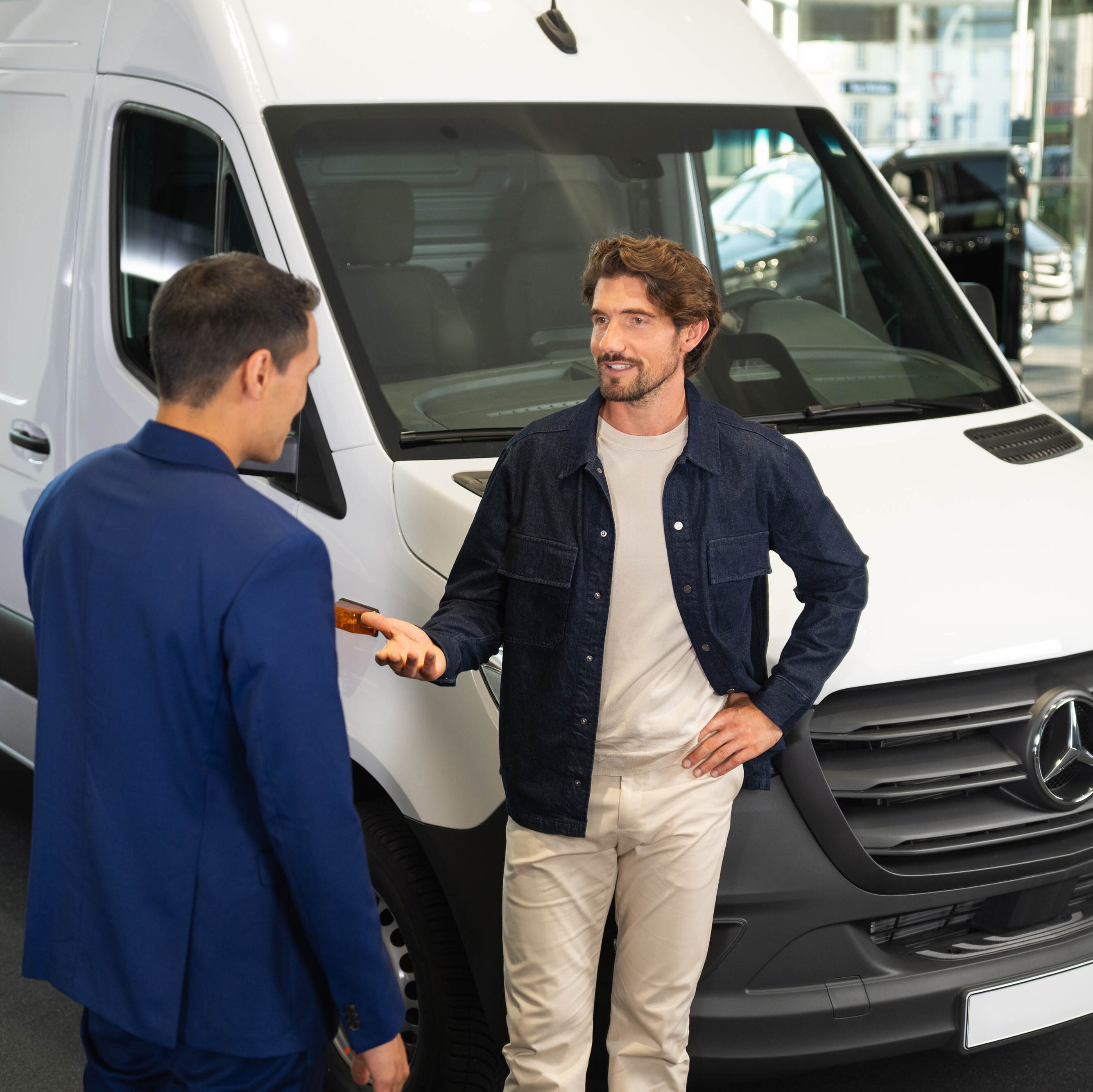 due persone che parlano accanto ad un furgone Mercedes-Benz