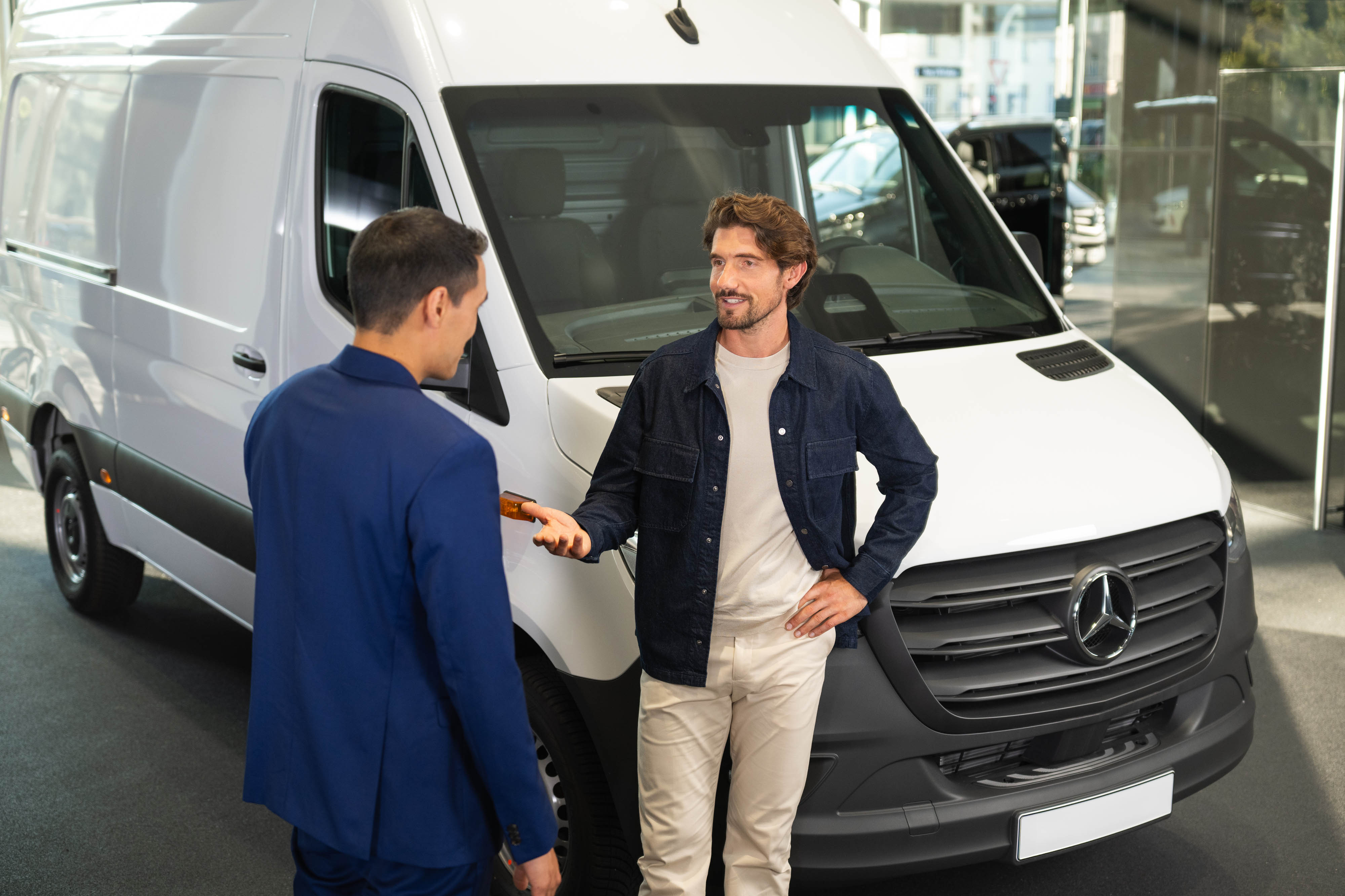 Servizi Assicurativi | Mercedes-Benz due persone che parlano accanto ad un furgone Mercedes-Benz
