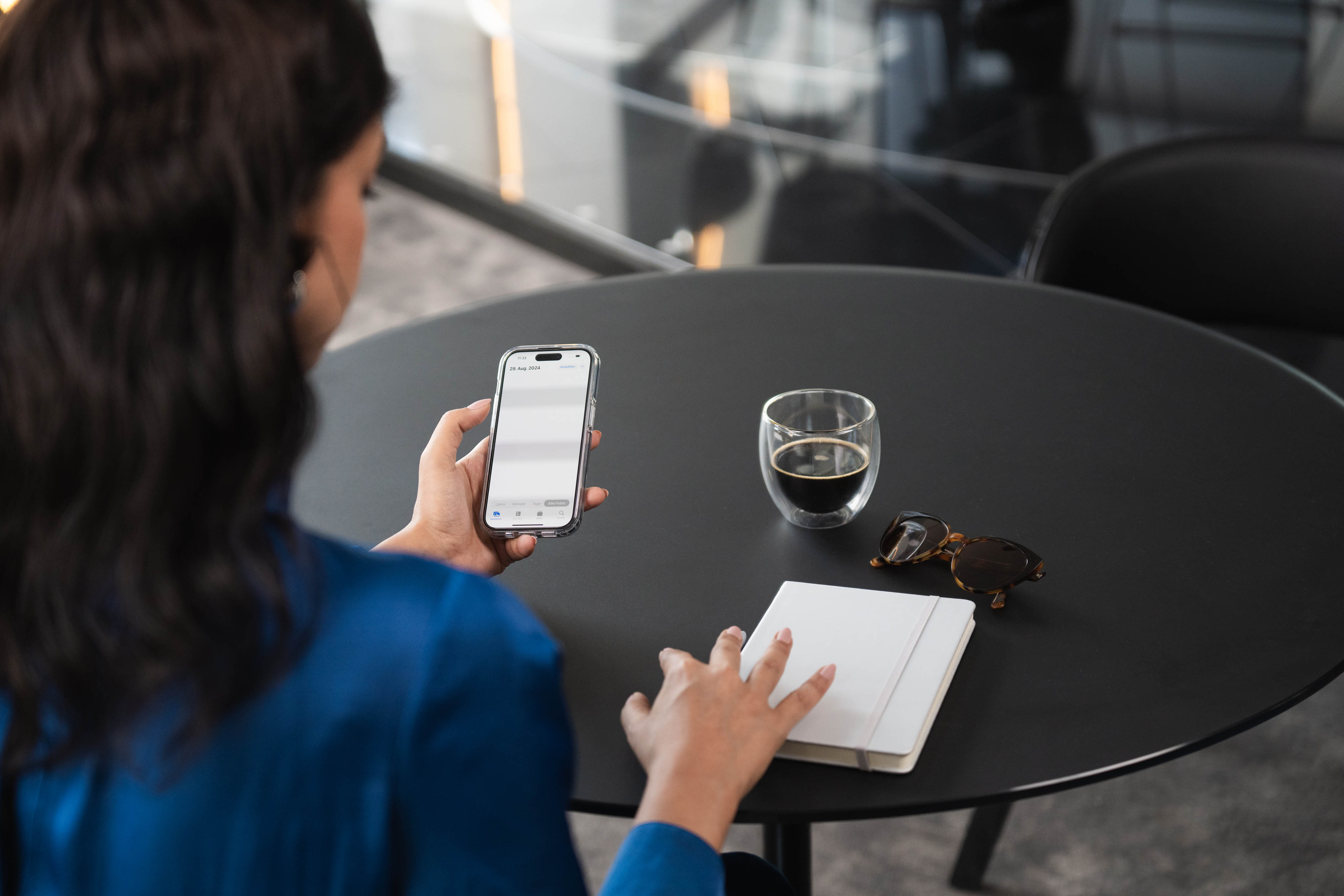 Portale Clienti Mercedes-Benz Financial | Mercedes-Benz Una donna con uno smartphone tra le mani e un taccuino sul tvolo