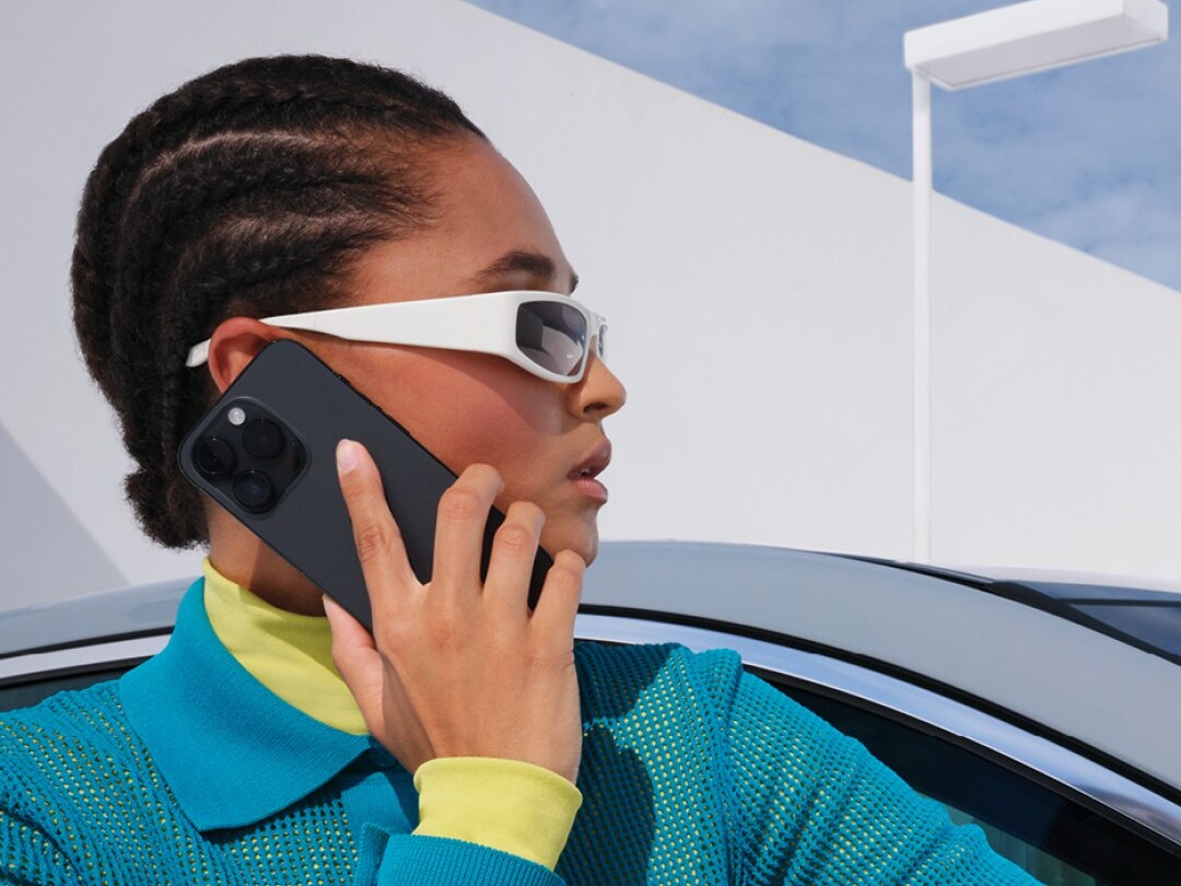 Una donna al telefono davanti a una vettura Mercedes-Benz