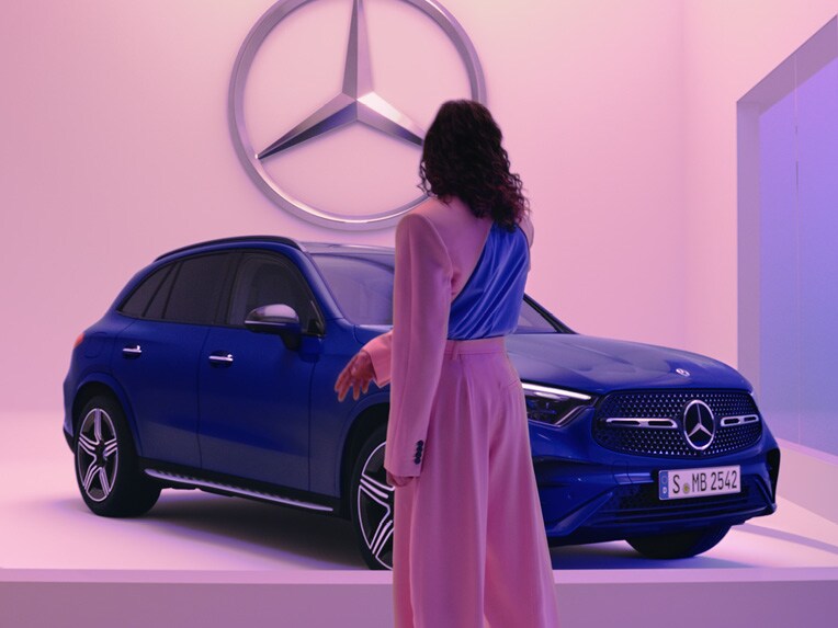 Una donna vestita di rosa di fronte uan GLC SUV