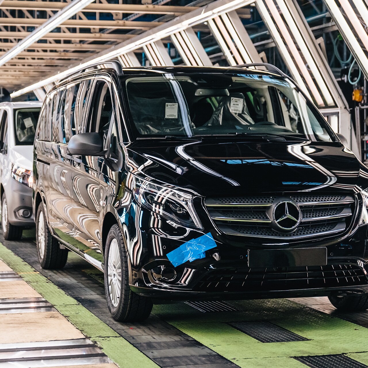 Una serie di Vito Mercedes-Benz avanzano su una linea di produzione