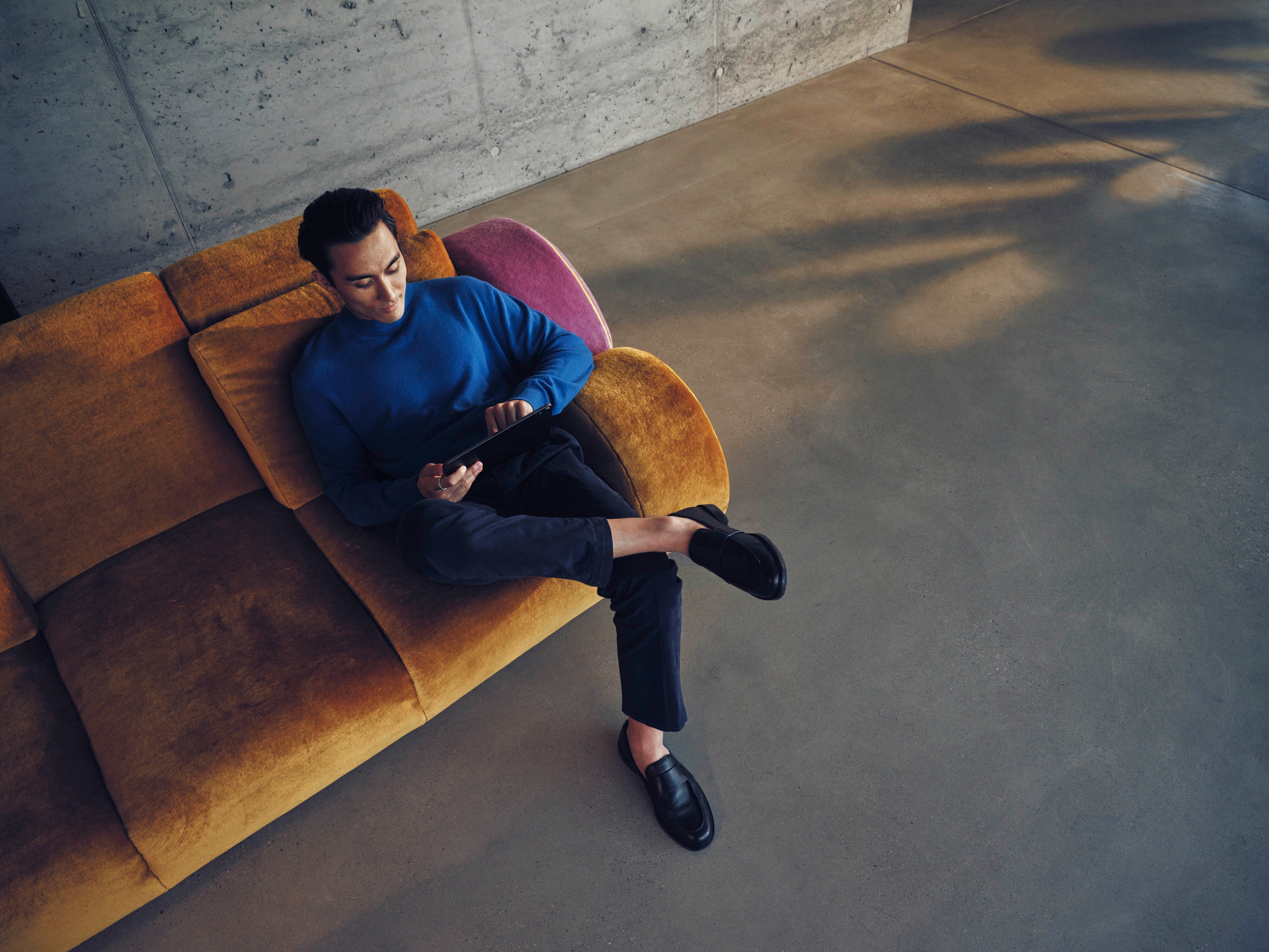 Un uomo sul divano utilizza lo smartphone