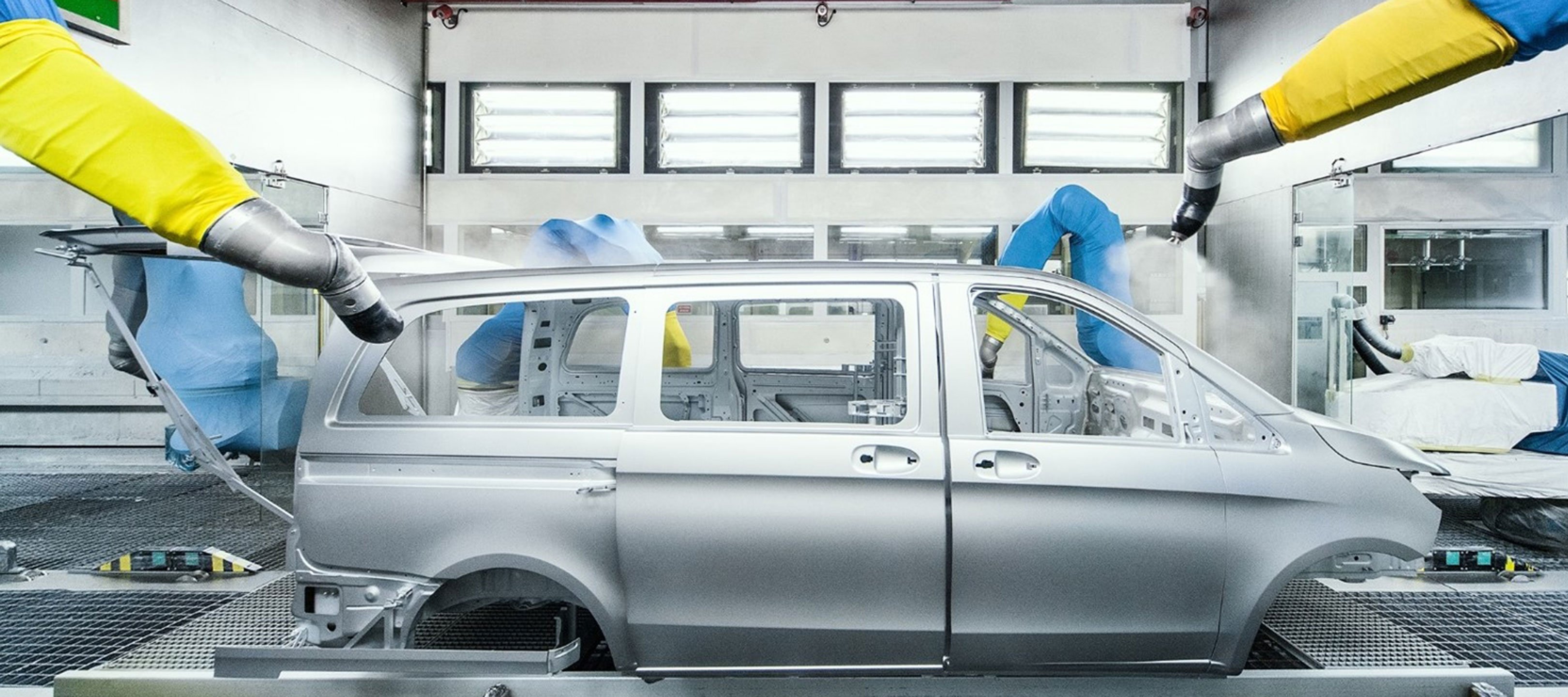 La carrozzeria di un Mercedes-Benz Vito mentre viene verniciata da diversi robot La carrozzeria di un Mercedes-Benz Vito mentre viene verniciata da diversi robot