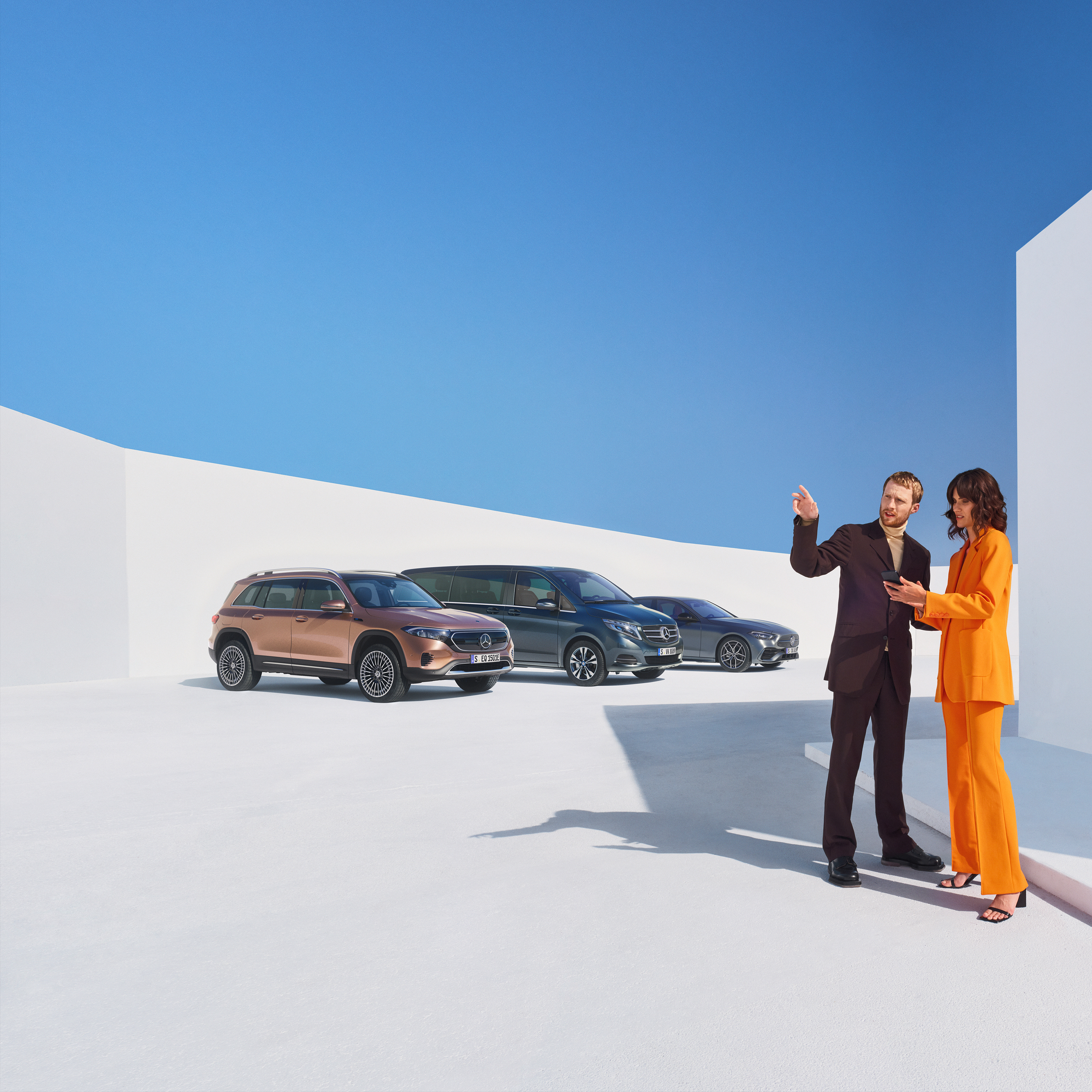 Business | Digital Extras Due persone parlano dei Digital Extras per clienti business. Sullo sfondo tre veicoli Mercedes-Benz.